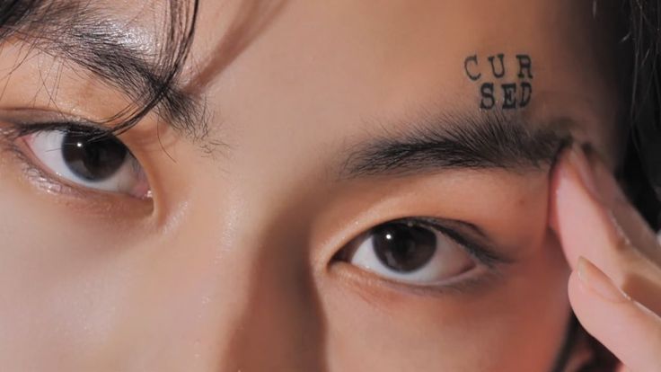 a close up of a person's face with the word curs written on their forehead