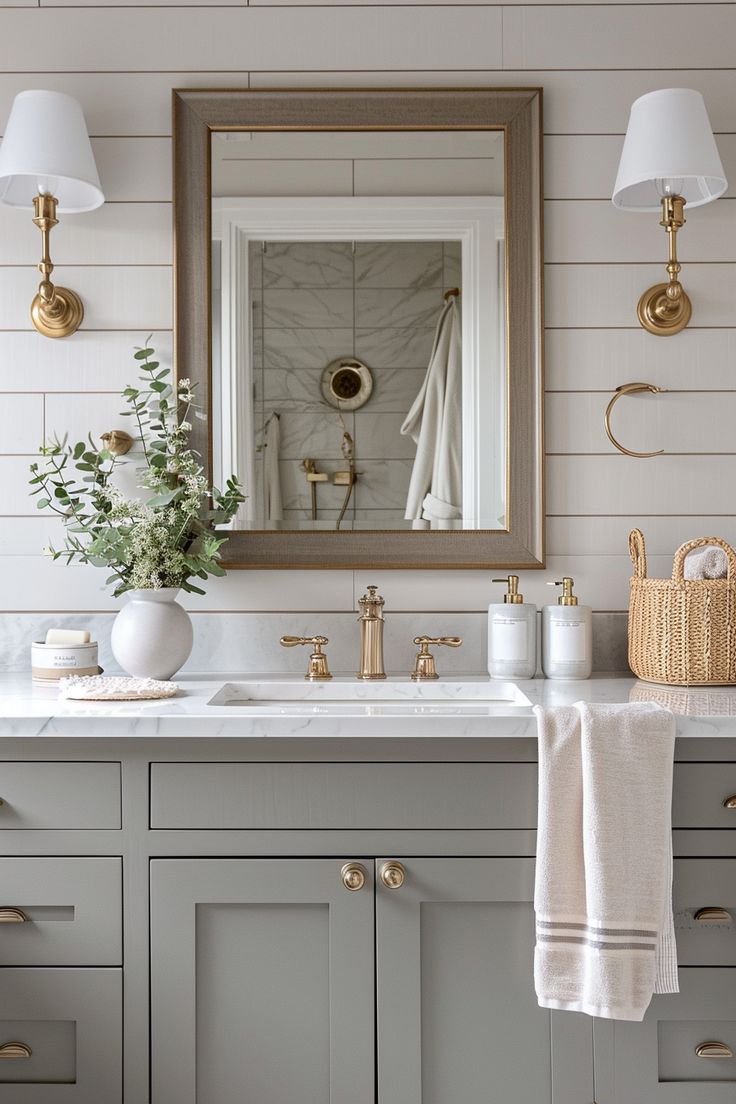 a bathroom vanity with two sinks and a large mirror above it, along with gold faucets