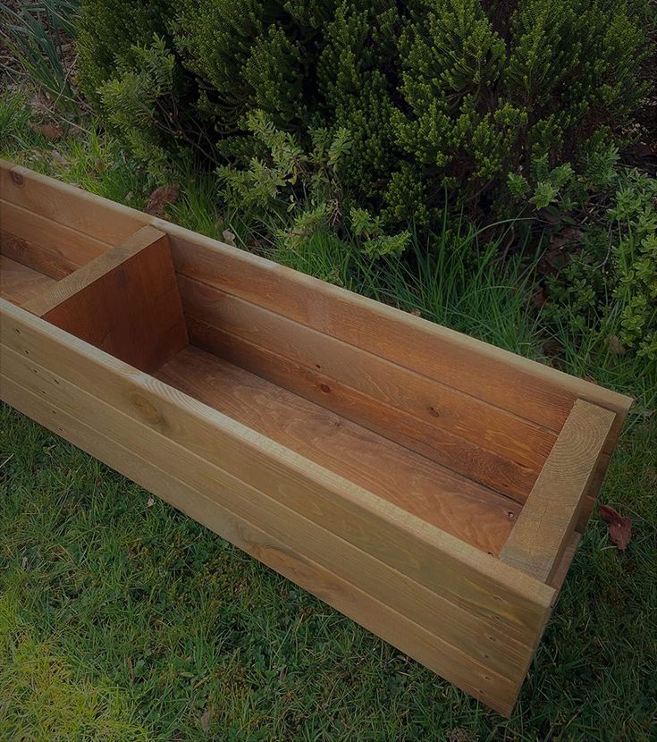 an empty wooden box sitting in the grass