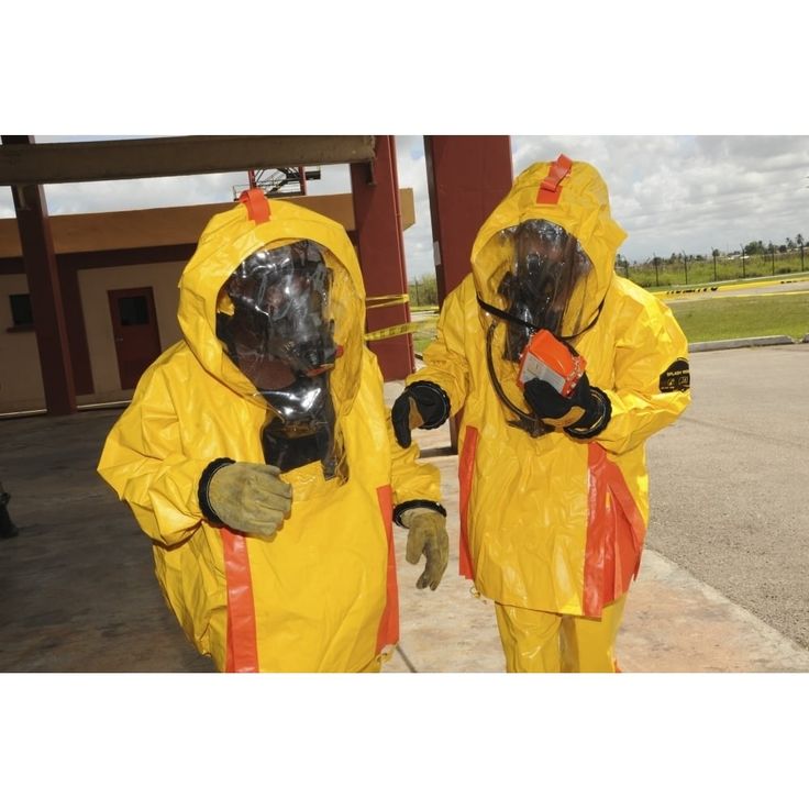 two people in yellow suits standing next to each other wearing gas masks on their faces