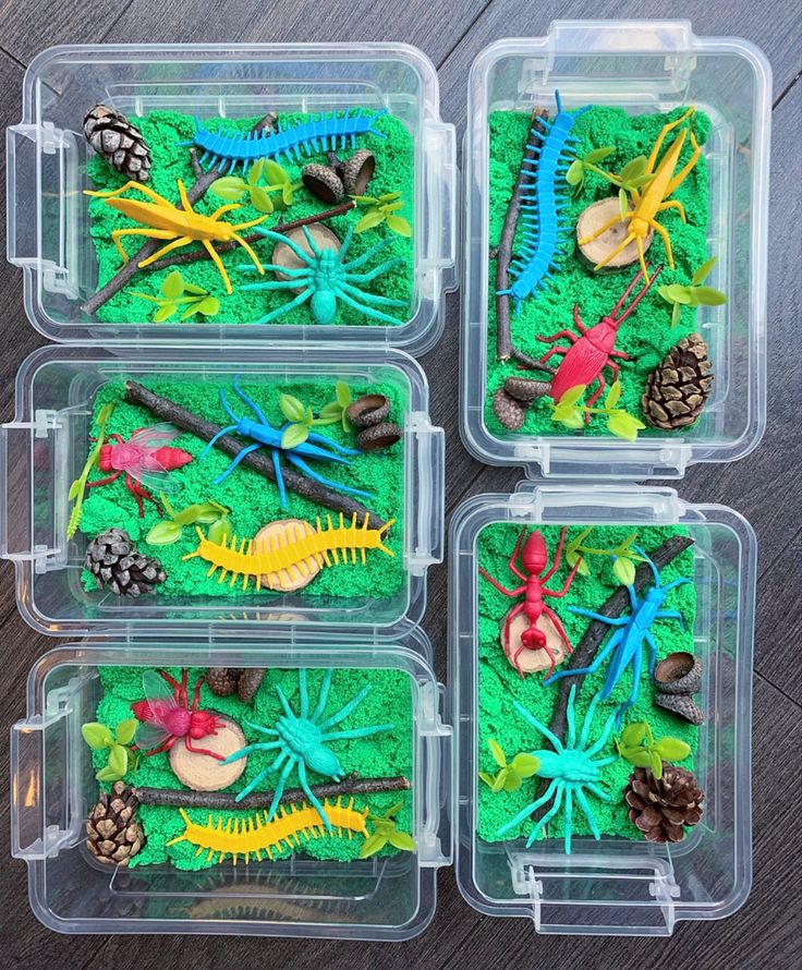 four plastic containers filled with different types of plants and animals in green mossy soil