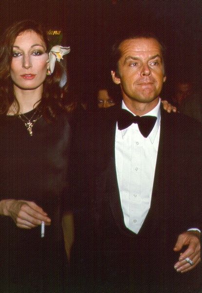 two people standing next to each other wearing tuxedos and bow ties at an event