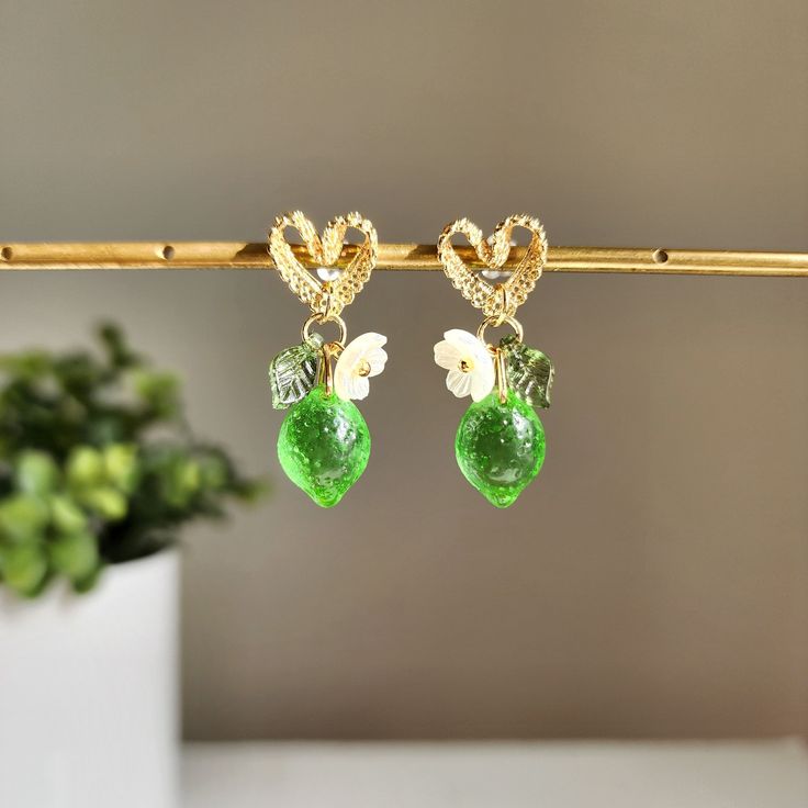 Discover the refreshing and zesty taste of lace heart lime earrings. There are many ways to incorporate these citrusy earrings into your daily outfit. Our lime lace heart stud earrings are made with Czech transparent glass lime, Czech opaque avocado lime, acrylic flowers, acrylic leaves and gold-plated lace heart stud earrings.Size: approx. ( W x L ) 0.5" x 1.25" Cute Green Jewelry For Party, Sweet Green Jewelry For Gifts, Trendy Lime Green Jewelry For Gift, Trendy Green Heart Earrings For Gift, Trendy Lime Green Jewelry As A Gift, Trendy Lime Green Jewelry Gift, Trendy Green Jewelry With Fruit Design, Cute Green Heart Earrings For Gift, Green Fruit Design Earrings As Gift