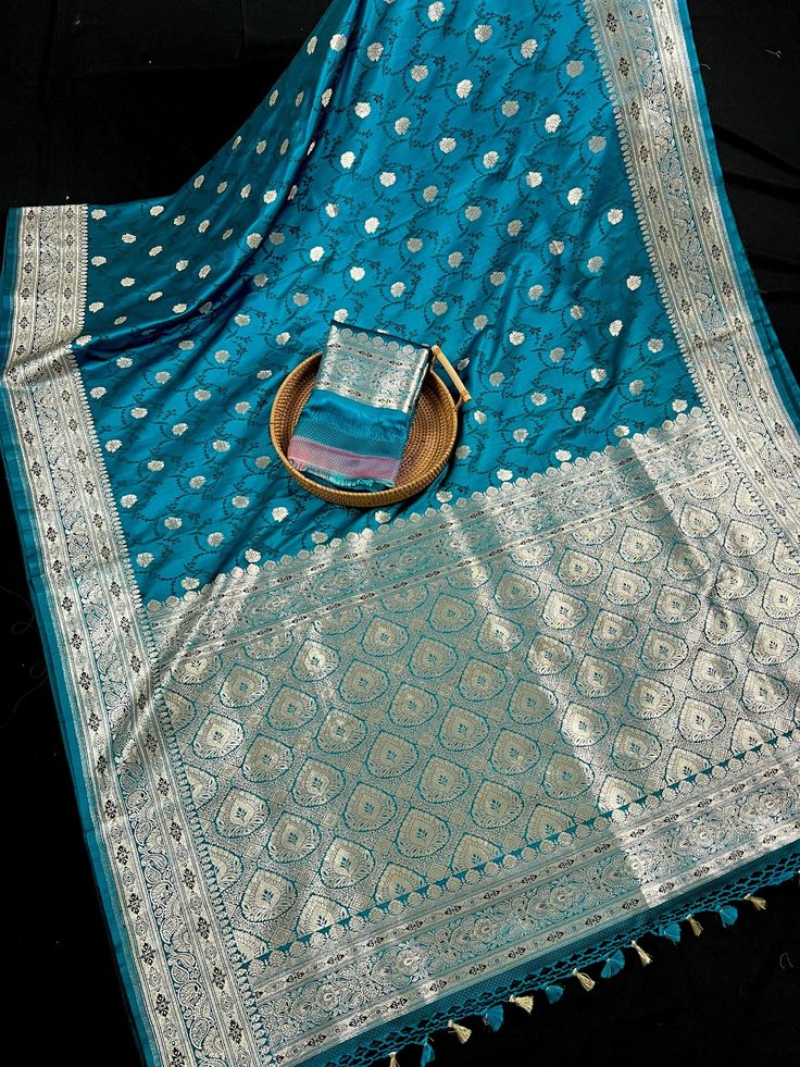 Statement Teal Color Mashru Silk Saree Handwoven Saree with Tanchoi Weave and Sliver Zari. Item : SareeColor : Teal Blue Base Fabric : Mashru Silk Blouse piece : YesFall & Edging(Pico) Yes/No : Yes Disclaimer -:- Color variation is possible due to various reasons like phone or desktop setting, resolution etc. Please don't hold us responsible. Our aim is to put the exact color of the Saree.- Colors are very Subjective. Hence a color understood by us can be different then yours. - If the Saree is Traditional Silver Pre-draped Saree With Pallu, Blue Meenakari Sets For Diwali, Traditional Silver Pre-draped Saree For Eid, Blue Sharara With Zari Weaving For Festivals, Traditional Silver Pre-draped Saree With Cutdana, Bollywood Style Silver Unstitched Traditional Wear, Blue Meenakari Sharara For Diwali, Blue Sharara With Traditional Drape And Zari Weaving, Blue Katan Silk Sets With Dupatta