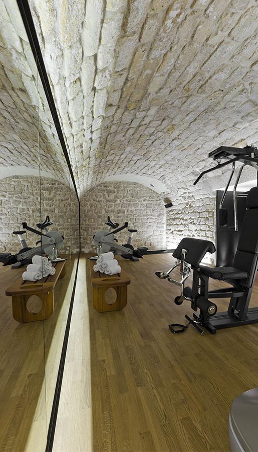 an indoor gym with exercise equipment in the center and on the other side as well as mirrors