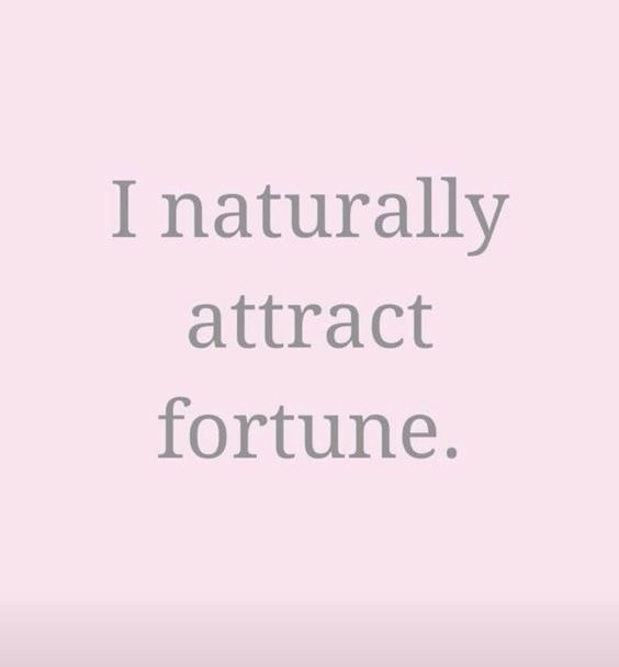 the words i naturally attract fortune are in grey and white on a light pink background