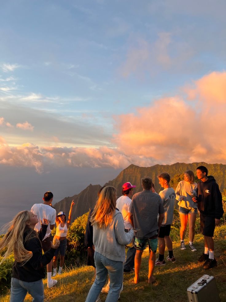 a group of people standing on top of a lush green hillside