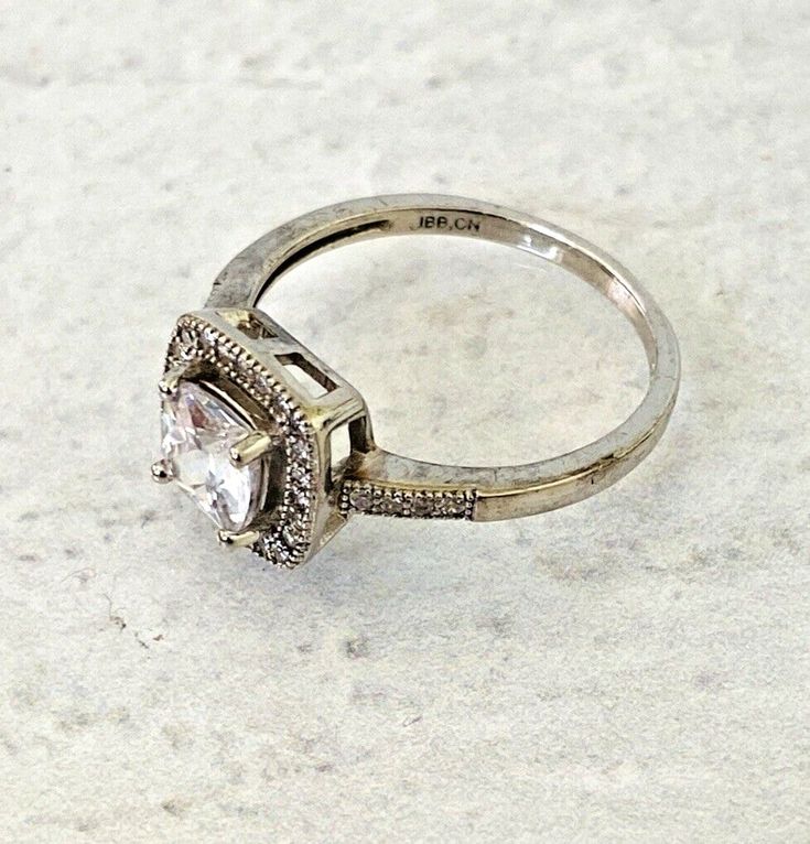 Vintage Sterling Silver Cubic Zirconia Halo Ring Size 7.75 - Bright Rhodium Plate - Lots of SparkleMain CZ is 1/4 inch (6mm) square.Band width is 1/16 inch (2mm)Setting is 3/8 inch (10mm)It is in very good condition, some areas of patina but most of the darker areas on the photos are ambient reflections.At the time of listing, we have a gorgeous line bracelet that is a perfect match, and a larger stone version of this ring. Please search our other items. New Romantics, Hinged Bangle, Silver Filigree, Halo Ring, Halo Rings, Ring Size 7, Metal Rings, Vintage Sterling Silver, Rhodium Plated