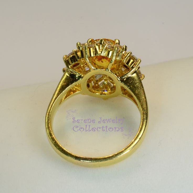 Thank you for coming in! This Vintage Ring has a strong striking yellow sapphire as its center piece. The sapphire is bezel set into a fancy setting with 8 heart and 8 round diamonds totaling 1.8 carats! Ring Size: 7.75 Total Weight: 9.58 grams Precious Metal: 18k solid gold Precious stones: -Yellow Sapphire: 2.92 carats, 9mm x 7.3mm -White Round Diamonds: 1.8 ct Hallmark: A18K Yellow Diamond Cluster Ring With Prong Setting, Luxury Gold Cluster Ring With Accent Stones, Oval Yellow Sapphire Ring With Center Stone, Gold Diamond Ring With Sapphire Center Stone, Yellow Oval Sapphire Ring With Prong Setting, Fine Jewelry Yellow Topaz Ring With Halo Setting, Yellow Oval Sapphire Diamond Ring, Yellow Sapphire Ring With Round Cut Gemstone, Oval Yellow Sapphire Ring With Diamonds