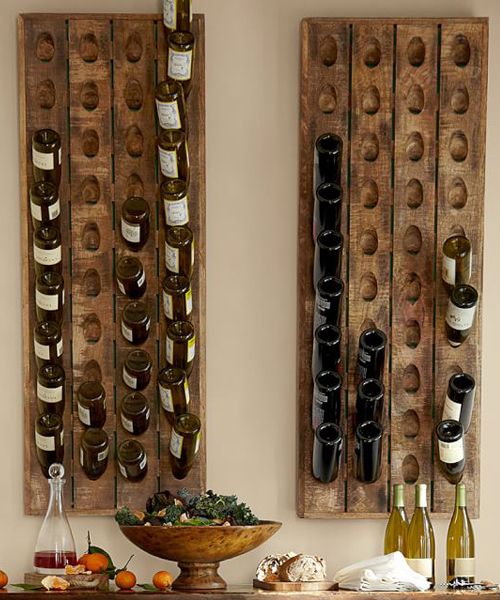 two wooden wine racks with bottles on top of them next to a bowl of fruit