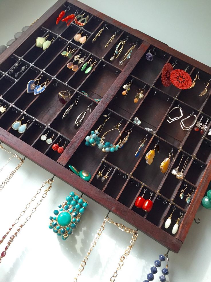 a wooden jewelry box filled with lots of necklaces