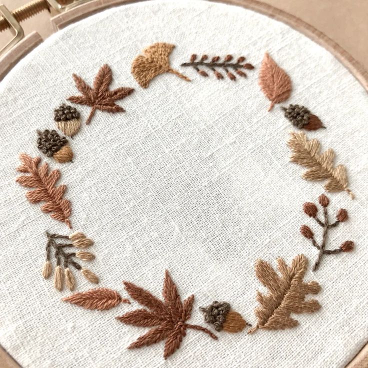 an embroidered wreath with leaves and acorns