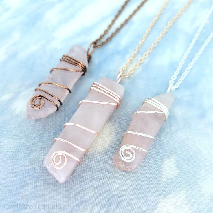 These lovely crystal pendants are handmade with beautiful polished pink raw rose quartz stone slabs wrapped with silver plated, rose gold plated, or antique copper jewelry wire and paired with your choice of 2mm cable chain necklace, or an 18-inch long black waxed cotton cord necklace. Each rose quartz crystal is unique, with varying saturation and size.  The pendants vary in size, measuring around 1.75 to 2.3 inches long, and they are around 0.4 inches wide. Please write a note in the message b Pink Rose Quartz Wire Wrapped Jewelry, Pink Rose Quartz Wire-wrapped Necklace, Pink Rose Quartz Wire Wrapped Necklace, Handmade Rose Quartz Jewelry In Rose Gold, Pink Wire Wrapped Crystal Pendant Necklace, Rose Gold Rose Quartz Hand-wrapped Jewelry, Pink Rose Quartz Hand Wrapped Jewelry, Hand Wrapped Rose Quartz Pink Jewelry, Hand Wrapped Rose Quartz Jewelry In Rose Gold