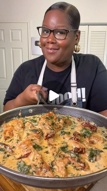 a woman is holding a large pan of food