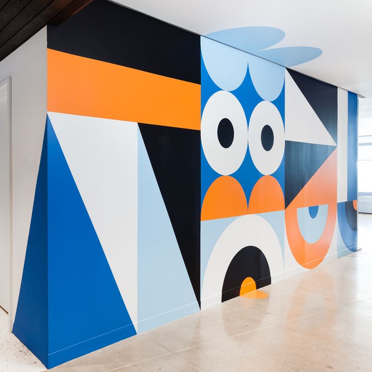 the colorful wall is painted with different shapes and colors, including blue, yellow, orange, and white