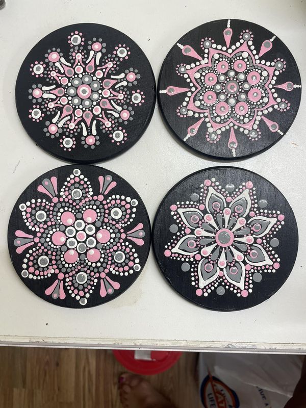 four black and pink coasters sitting on top of a table