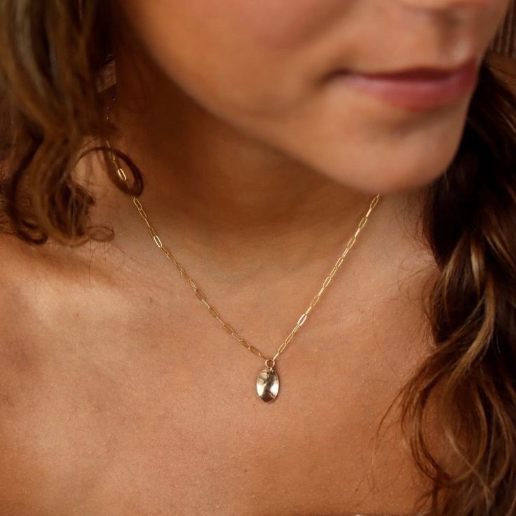 With a hammered oval charm pendant on our Narrow Links chain, the Olivia Necklace adds a touch of whimsy to any outfit. Want to create a set?! Pair this piece with our bestselling Olivia Ring! DETAILSPendant measures at 0.8"Available in 14", 16", or 18"Available in 14k Gold FillHypoallergenic, Nickel-Free, and Water Safe Dainty Oval Charm Necklace For Everyday, Dainty Oval Charm Necklaces, Dainty Oval Charms Necklaces, Dainty Oval Necklaces With Charms, Dainty Oval Link Charm Necklace For Gift, Minimalist Oval Link Charm Necklace As Gift, Elegant Hammered Oval Pendant Jewelry, Minimalist Oval Charm Necklace For Everyday, Dainty Charm Necklace With Oval Pendant And Delicate Chain