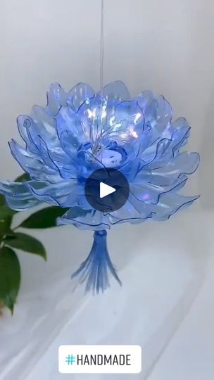 a blue glass flower hanging from a ceiling