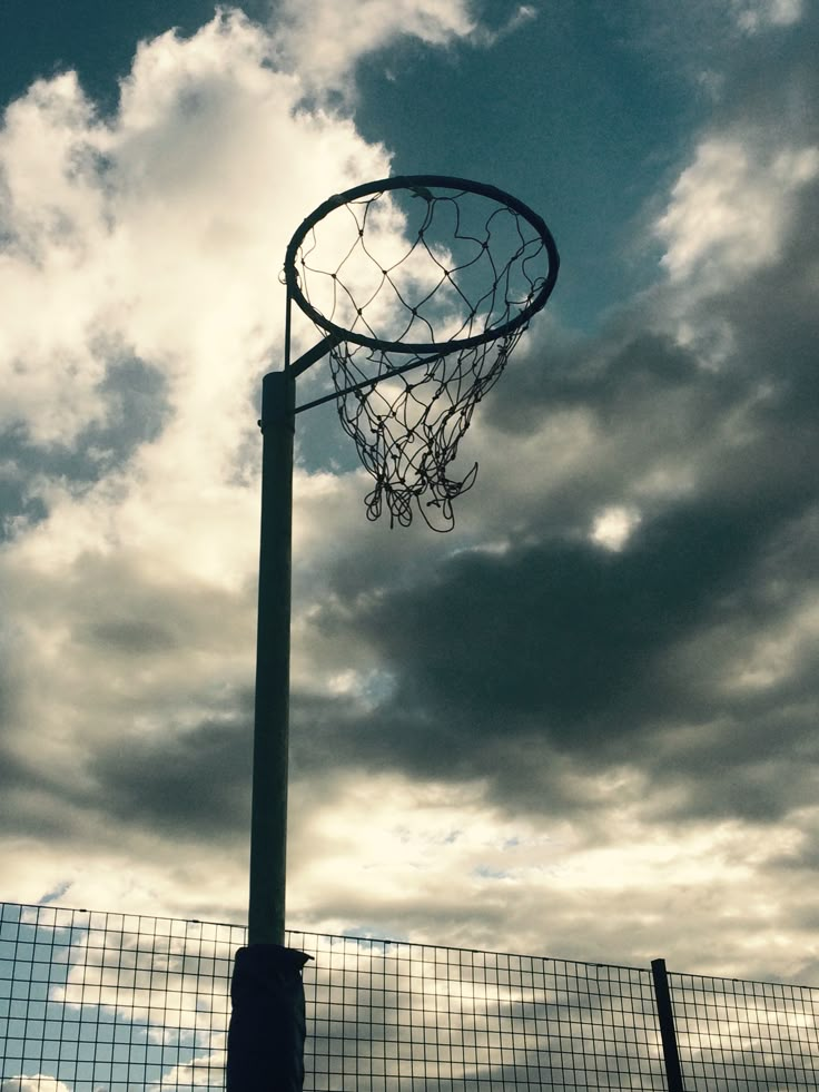 a basketball hoop in front of a cloudy sky