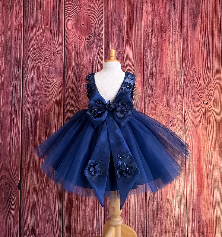 Navy Blue 3D Embroidery Dress -Knee Length  This sleeveless bodice consists of Navy Blue 3D floral embroidery with sowed in pearls, the back of the dress consists of soft sheer organza material with a deep elegant V-back with a hidden zipper. The bow is made of sheer organza with floral embroidery with tails. (Easily Detachable)The skirt consists of 4 tulle layers and 2 layers of lining with crinoline for fullness.  Dress Is Pictured with a petticoat NOT INCLUDED https://www.etsy.com/listing/1316417982/white-knee-length-petticoat-wedding?click_key=41cb8b0ae4587efa582b0a433f3f5e0cde12aec0%3A1316417982&click_sum=af1df37b&ref=shop_home_active_1 Visit our store, more items to come!  https://www.etsy.com/shop/LittledarlnBoutique?ref=profile_header CUSTOM MEASUREMENTS AVAILABLE All custom orders Blue Pageant Dress For Spring Wedding, Bridesmaid Princess Dress With Floral Applique In Tulle, Floral Applique Tutu Dress For Bridesmaid, Royal Blue Fitted Princess Dress For Wedding, Princess Style Bridesmaid Dress With Floral Applique, Spring Wedding Blue Pageant Dress, Blue Spring Pageant Dress For Party, Princess Style Tutu Dress With Floral Applique For Party, Blue Floral Applique Gown For Party