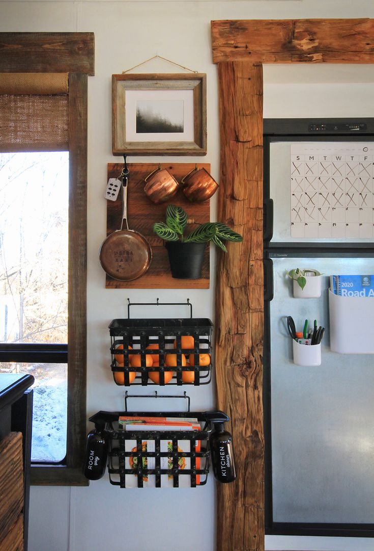 a kitchen with a refrigerator, potted plant and other items on the wall above it