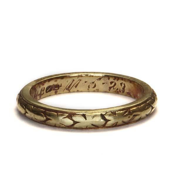 an antique gold wedding ring with writing on it