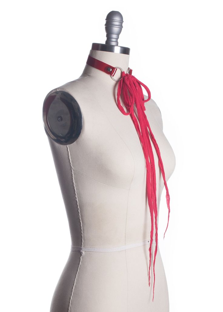 High quality post apocalyptic choker collar made in thick red PVC. Shredded gauze closure. Can be worn tied in a bow for an edgy, gothic doll look. Can be worn many other ways, with the long gauze ties tied in a knot, wrapped around the neck or body, and with the ties in front or back. Silver-toned nickel plated steel hardware. Shown in translucent red PVC.Also available in red leather. SMALL/MEDIUM (11-13")MEDIUM/LARGE (13-15")LARGE/X-LARGE (15-17") Custom sizing available. All pieces are MADE