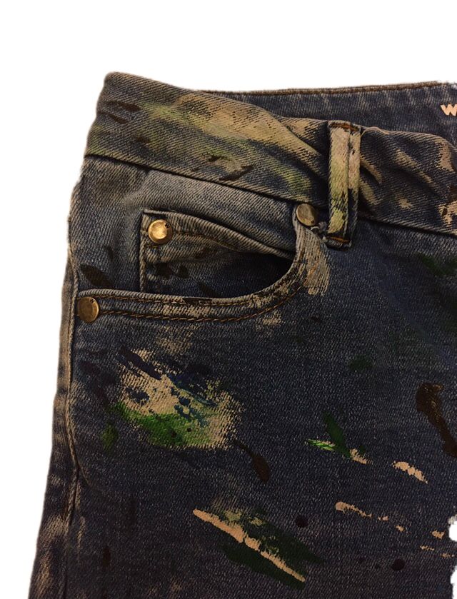 an old pair of jeans with paint splattered on it