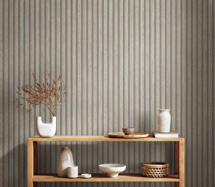 a shelf with vases and bowls on it in front of a striped wallpaper