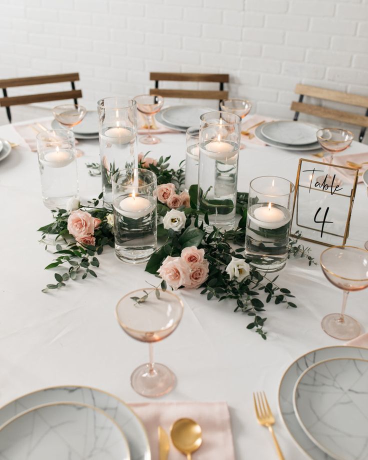 the table is set with candles, plates and place settings for an elegant wedding reception