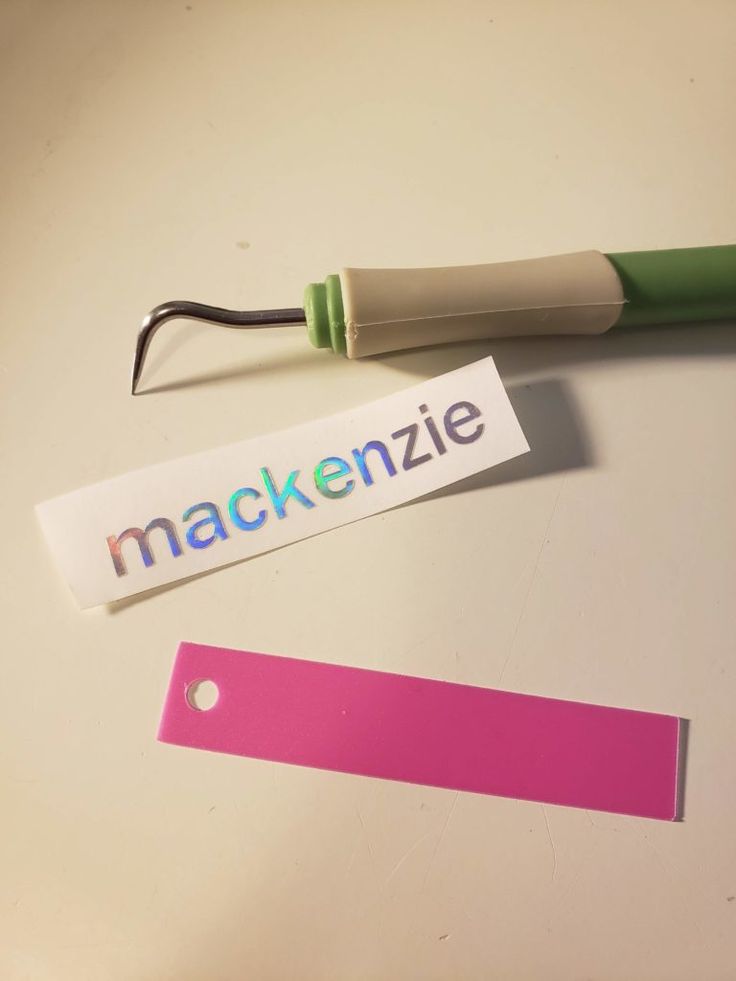 a green and white toothbrush sitting on top of a table next to a name tag