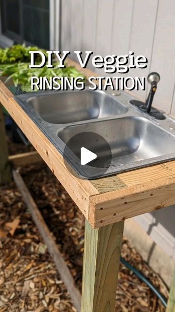 a sink sitting on top of a wooden table in front of a building with the words diy veggie rinsing station