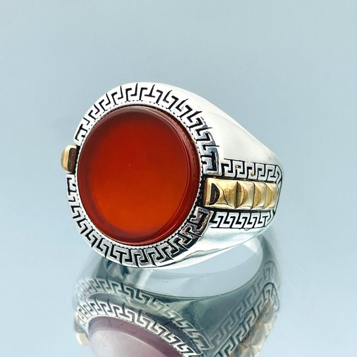 Discover the timeless beauty of our Yemeni Aqeeq Ring, meticulously handcrafted with love and care. Made from 925 Sterling Silver, this exquisite men's ring combines traditional craftsmanship with a touch of elegance. The centerpiece of this striking piece is a genuine Yemeni Aqeeq stone, known for its deep red hues and believed to hold mystical and protective properties. Each stone is carefully selected to ensure its unique and captivating patterns, making every ring a one-of-a-kind masterpiece. This Yemeni Aqeeq Ring isn't just a piece of jewelry; it's a statement of style and heritage. Its bold yet refined design is reminiscent of Ottoman aesthetics, reflecting a rich history and culture. Whether you wear it as a symbol of strength, protection, or simply as a fashion statement, this rin Elegant Round Carnelian Signet Ring, Red Carnelian Hallmarked Rings, Carnelian Signet Ring For Anniversary, Elegant Carnelian Signet Ring As Gift, Red Carnelian Signet Ring For Anniversary, Classic Agate Ring As A Gift, Classic Agate Ring As Gift, Elegant Carnelian Signet Ring For Gift, Classic Agate Rings For Gifts