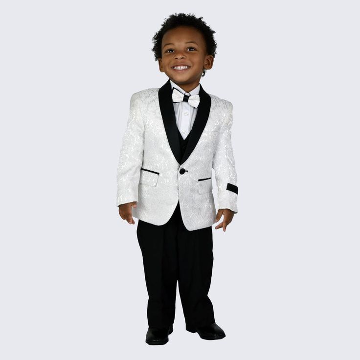 a young boy wearing a white tuxedo and black bow tie