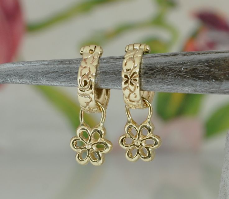 "14k solid gold hoop earrings. Small Hoop earrings, slightly engraved with gentle elements: flowers, leaves, and other surprises. A gold handmade symmetric flower with 6 leaves is hanging on each one of the hoop earrings. You can hang special charms on the earrings, and make them a piece of glamorous jewelry. These earrings are definitely a perfect gold gift for a woman. You can wear these earrings with every color or style of close; with a dress with denim, with a suit or a wight shirt. ** 14 k Yellow Gold Flower Shaped Hoop Earrings As Gift, Yellow Gold Flower-shaped Hoop Earrings Gift, Gold Small Hoop Earrings With Flower Charm, Small Hoop Earrings With Flower Charm In Gold, Gift Flower Shaped Yellow Gold Hoop Earrings, Unconventional Engagement Rings, Unique Hoop Earrings, Gold Hoop Earring, Glamorous Jewelry