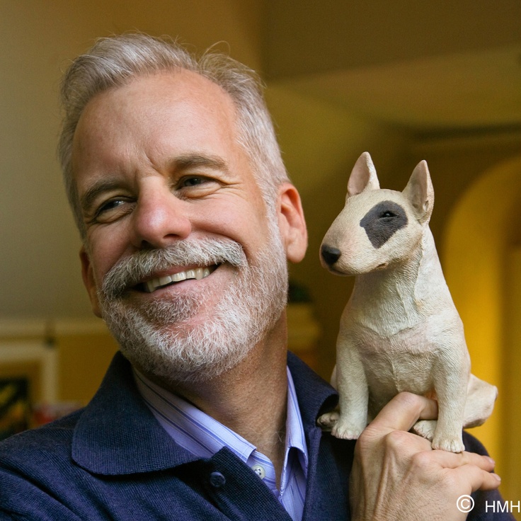 a man holding a stuffed dog in his right hand