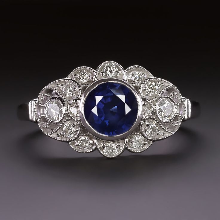 an antique sapphire and diamond ring, with three diamonds around it's center stone