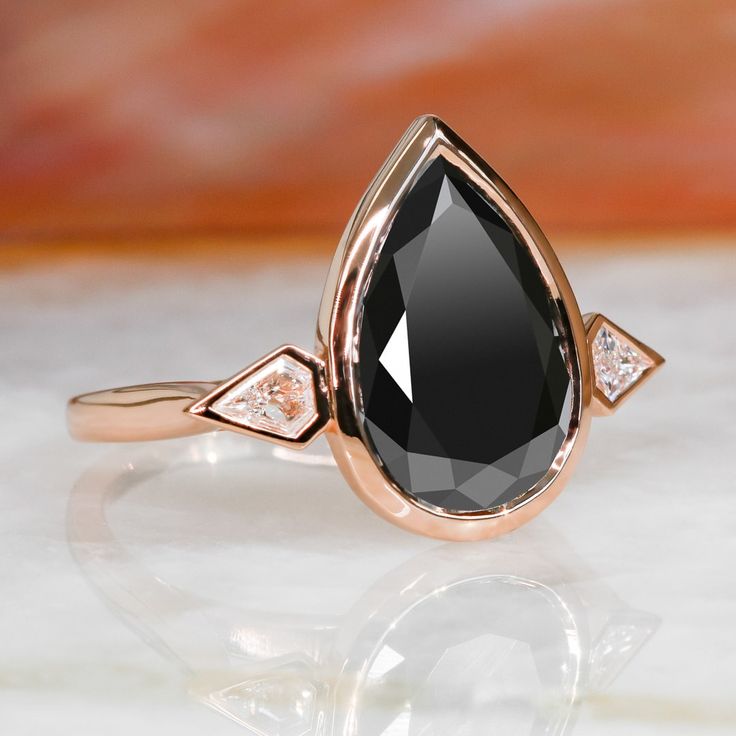 a rose gold ring with a black diamond