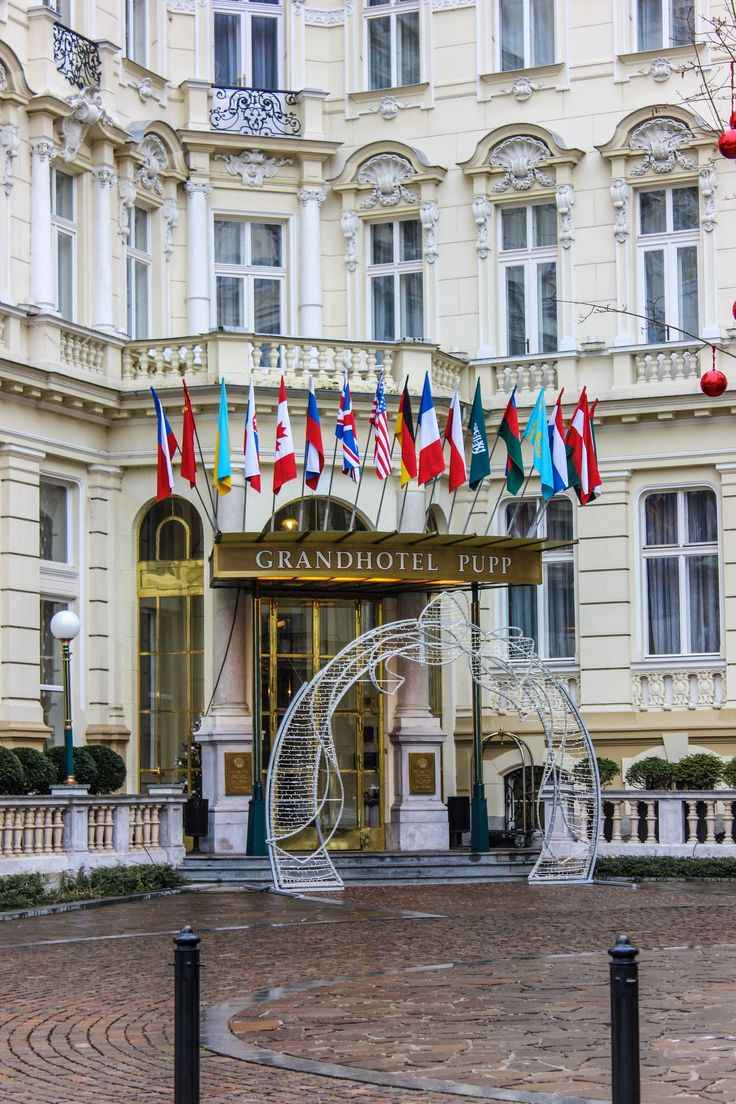 the grand hotel has many flags flying in front of it's doors and windows