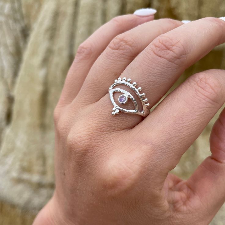 Eye of Protection Sterling Silver Ring This Sterling Silver handcrafted ring has been made with intention, magic and protection. The Evil eye is a talisman believed to create spiritual protection. This piece has been crafted with a heavily beaten organic texture creating a modern ancient aesthetic. Made with magical Rainbow Moonstone our jewels are here to make you feel empowered and radiant. Our jewels are here to make you feel empowered and radiant. * Triple Moonstone Ring * Fit for a queen, the ultimate statement ring * High quality Sterling Silver * Beautifully detailed bands * Lead & Nickel free * Also available in 14K Gold Rainbow Moonstone Wildly feminine and overflowing with goddess energy. Our dreamy Rainbow Moonstone promotes all kinds of magic and deliciousness, such as self-exp Spiritual Open Ring With Birthstone, Mystical Moonstone Promise Ring, Mystical Moon Phase Jewelry For Promise, Spiritual Crystal Ring With Stone Setting For Promise, Mystical Handmade Open Ring, Spiritual Sterling Silver Moonstone Promise Ring, Spiritual Moonstone Birthstone Ring For Healing, Mystical Moonstone Rings With Birthstone, Spiritual Promise Rings