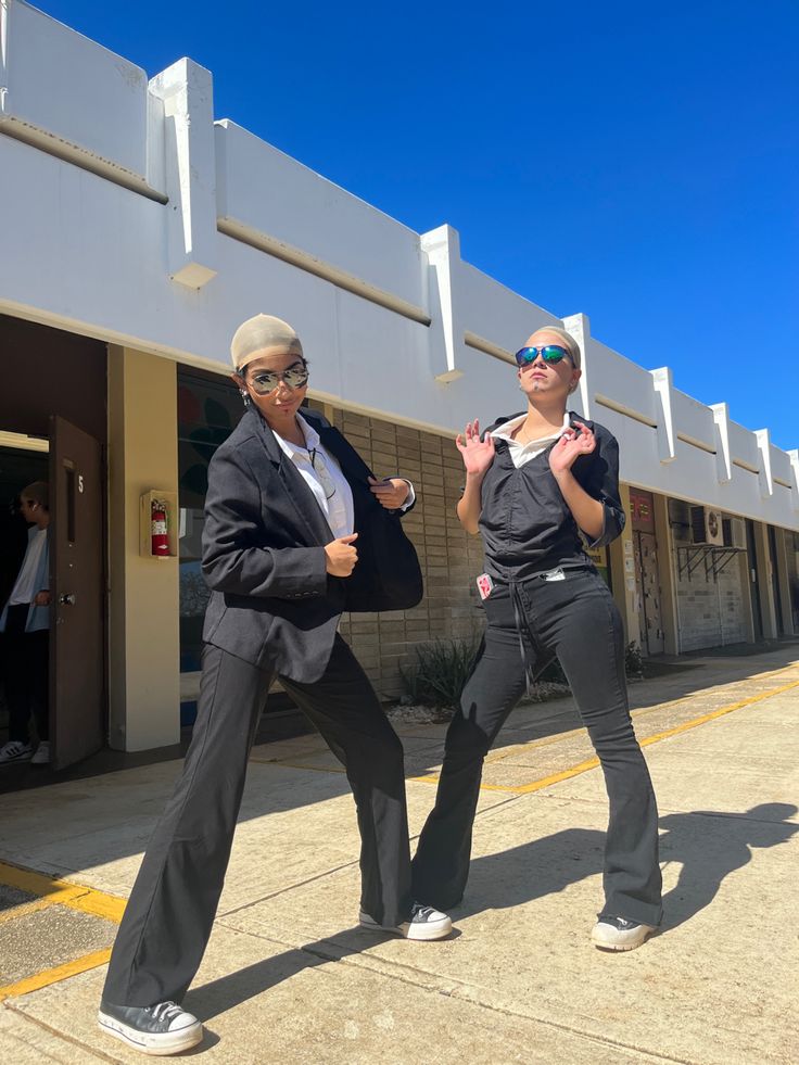 two women in business attire are dancing outside