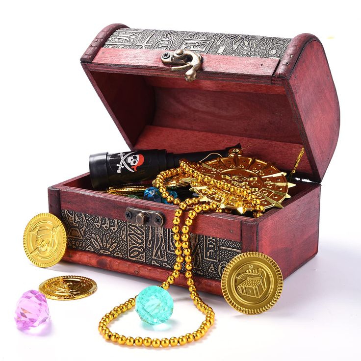 an open wooden chest with gold jewelry and other items in it on a white surface