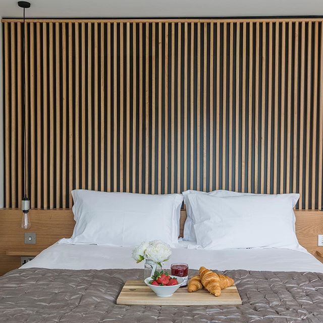 a tray with food on top of a bed next to pillows and pillowcases