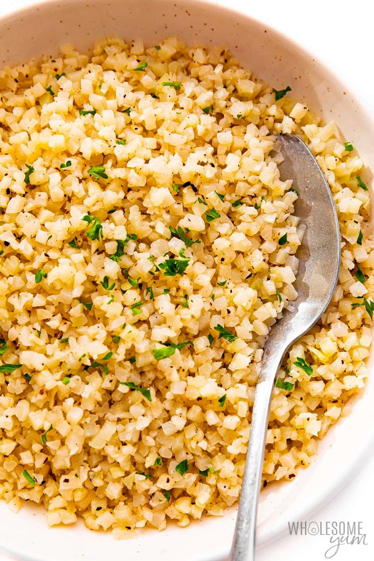 a bowl full of rice with a spoon in it