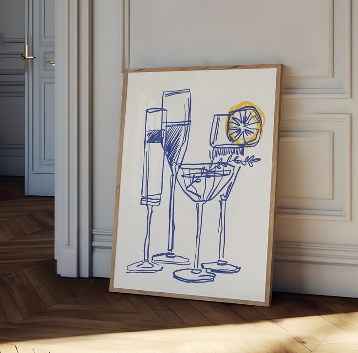 a drawing of two champagne glasses on the floor next to a framed art print with an orange slice in it