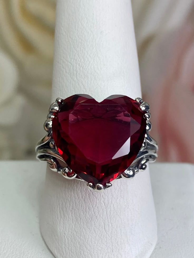 Red Heart Gem Sterling Silver RingHeart Leaf Design#D213 This Gothic inspired lovely filigree ring is set with a 10ct flawless red gemstone. This heart gemstone is 15mm x 15mm. The rings sits 11mm off the finger. Notice the beautiful gothic design of the silver filigree setting and band. The inside of the band is marked 925 for sterling silver. This is an exquisite rendition of an antique filigree ring. The sterling filigree cradles the stone in a delicate caress. Classic and beautiful, this vin Red Round Jewelry For Valentine's Day, Victorian Heart-shaped Jewelry For Anniversary, Heart Cut Ruby Jewelry, Red Heart Shaped Wedding Rings, Fine Ruby Heart Jewelry, Fine Ruby Heart-shaped Jewelry, Elegant Lab-created Ruby Jewelry For Valentine's Day, Formal Heart-shaped Jewelry With Intricate Design, Formal Heart-shaped Filigree Jewelry