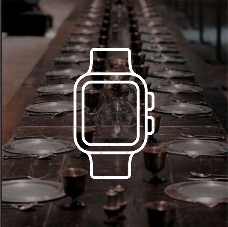 a long table with many empty plates and glasses on it, including a watch in the middle