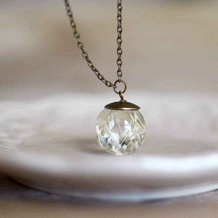 This delicate handcrafted resin sphere holds a cluster of a beautiful Gypsophila, better known as "Baby's Breath". Hand-cast and hand-polished to luster, pendant measures approximately 2 cm in diameter and comes to wear on the 18 inches long chain. Very delicate and dainty, this necklace is perfect for the wedding, elegant outfit or just every day!Please make your choice of a bronze or silver tone chain.Note: flowers in nature do not look exactly alike, so there will be some slight variations in Clear Drop Necklace As A Gift, Clear Drop Necklace For Gifts, Clear Drop Necklace For Gifting, Clear Drop Necklace For Gift, Delicate Round Hypoallergenic Necklace, Delicate Round Crystal Necklace For Gift, Clear Crystal Necklace With Round Beads As A Gift, Delicate Hypoallergenic Round Necklace, Delicate Round Crystal Necklaces For Gift