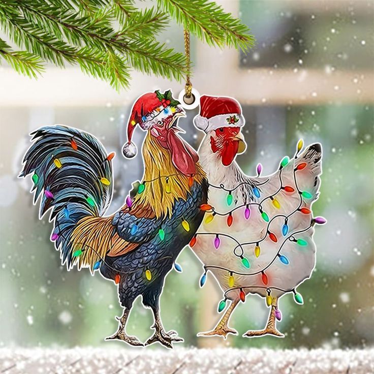 two roosters are hanging from a christmas tree