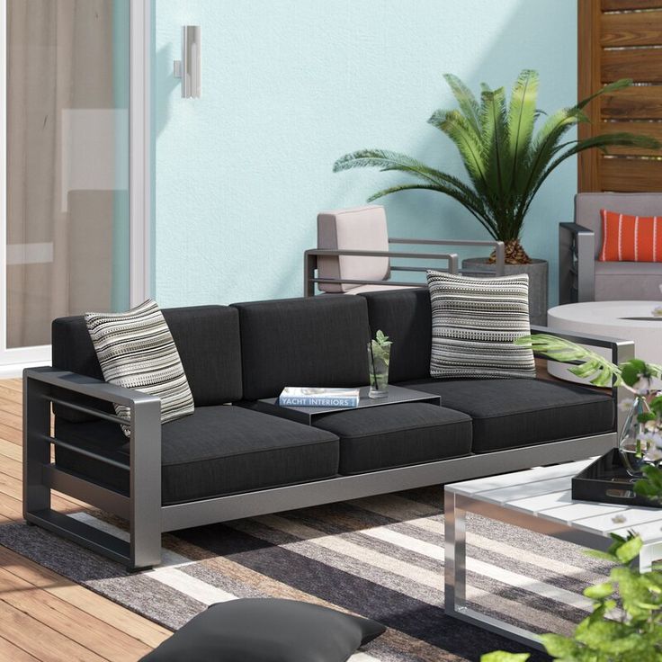 a living room filled with lots of furniture next to a patio table and potted plant